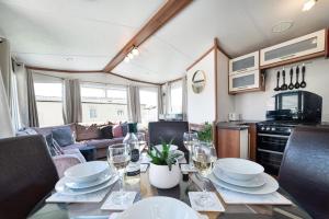 a dining room with a table with wine glasses at Dog Friendly Lovely Caravan by Beach Prestatyn N Wales 6 Berth Read full Host details before booking Mon in to Fri out Fri in to Mon out Mon to Mon Fri to Fri ONLY in Prestatyn +29 photos