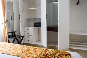 a room with a bed and a closet with a pizza at Brickwood Apartments in Nairobi