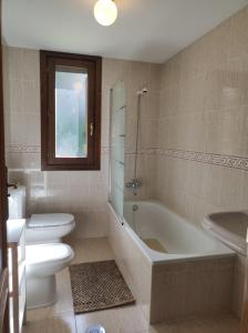 Un baño con inodoro, bañera y lavabo. en Los Avellanos de Escarrilla - tucasaenlospirineos, en Escarrilla 37 fotos más