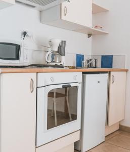 a kitchen with a microwave and a stove at Résidence Idéal-Subrini in Porto Ota