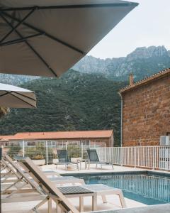 een patio met stoelen en een zwembad met bergen op de achtergrond bij Résidence Idéal-Subrini in Porto Ota