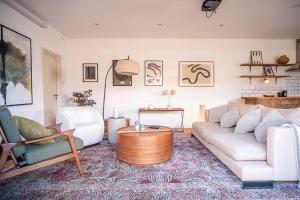 a living room with a white couch and a coffee table at Penthouse at The Old Tea Factory in London