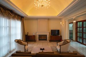 a living room with a fireplace and a chandelier at ArdenHill Resort & Golf in Jeju