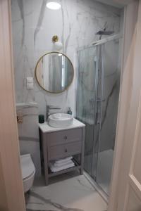 a bathroom with a shower and a sink and a mirror at Apartamenty al Mare Sopot in Sopot