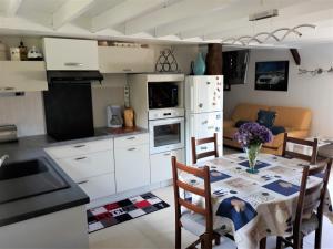 a kitchen and dining room with a table and chairs at Paradis pour les petits, quiétude pour les grands. in Brech