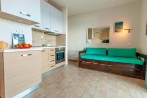 a kitchen with a green couch in a room at Glyfada New Era Home 120 Menigos Resort Apartments in Glyfada