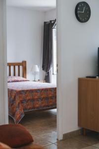 1 dormitorio con 1 cama y reloj en la pared en Résidence Idéal-Subrini, en Porto Ota