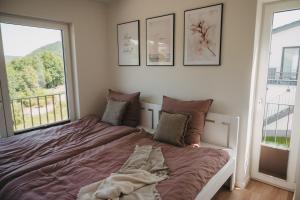 ein Bett in einem Schlafzimmer mit einem großen Fenster in der Unterkunft Ferienhaus Heimathafen am Diemelsee, Willingen, Winterberg in Diemelsee