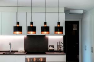 une cuisine avec plusieurs lumières suspendues au plafond dans l'établissement Liom Apartment by Quokka 360 - one-bedroom design apartment with balcony, à Gudo