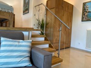 eine Treppe in einem Wohnzimmer mit Sofa in der Unterkunft Olivenblatt 4 in Bardolino