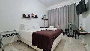 a hotel room with a bed and a television at Studio_Copa_Clara in Rio de Janeiro