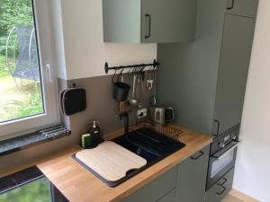 a kitchen with a counter with a sink and a window at Ostsee Hafenkoje - Lübeck-Travemünde Priwall in Lübeck