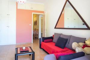 a living room with a red couch and a teddy bear at Mema's Tranquil Apartment in Patra in Patra