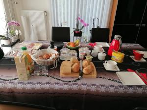 a table with bread and other food on it at Le Cerisier in Bioul