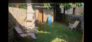 um quintal com duas cadeiras e uma porta amarela em Casa jardin Mariana em Lubián