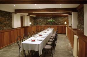 a long table with white tables and chairs in a room at Hotel y Apartamentos Arias in Navia