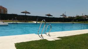 una piscina con una escultura de metal en la hierba en Holidays2Cala del Moral & terraza & vista mar & piscina & parking, en Cala del Moral