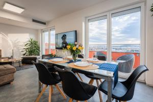 a dining room with a table and chairs with a view at Penthouse Letňanské zahrady in Prague