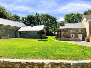une maison en pierre avec une cour gazonnée devant dans l'établissement Hafan Hedd - Romantic Rural Retreat in Pembrokeshire, à Solva