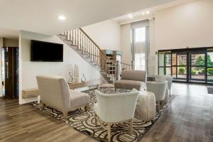 una sala de estar con un montón de sillas y una escalera en Clarion Pointe Atlanta Airport College Park, en Atlanta