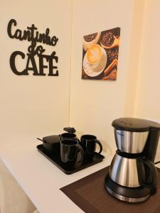 eine Kaffeemaschine auf einer Theke mit einer Kaffeekanne in der Unterkunft Flat Comfort Beira Mar Manaíra in João Pessoa