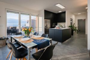 a kitchen and dining room with a table and chairs at Penthouse Letňanské zahrady in Prague