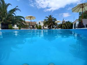 uma grande piscina azul com guarda-sóis em PALMAR CLUB - Villa ZENOBIA em Vraná