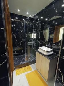 a black bathroom with a sink and a mirror at Aprt Hassan rba in Rabat