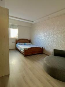 a bedroom with a bed and a window and a couch at Aprt Hassan rba in Rabat