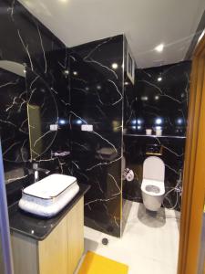 a bathroom with a toilet and a black marble wall at Aprt Hassan rba in Rabat