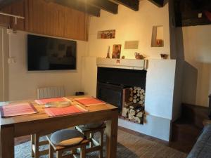 uma sala de estar com uma mesa e uma lareira em CHARMANT CHALET dans les monts du Forez em Le Fayt