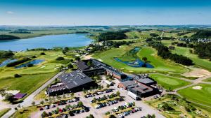 - une vue aérienne sur un parcours de golf avec un lac dans l'établissement HimmerLand, à Gatten