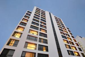a tall white building with many windows at BelAire Bangkok Sukhumvit in Bangkok