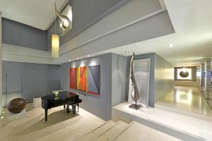 a living room with a piano and a painting on the wall at BelAire Bangkok Sukhumvit - SHA Extra Plus in Bangkok