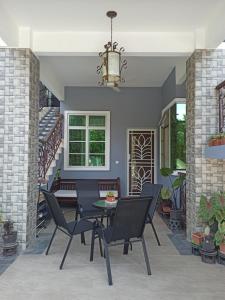 a patio with a table and chairs and stairs at Darney's Homestay Kg Bangau Tanjung in Temerloh