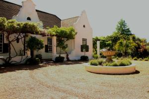 a house with a fountain in the middle of a yard at Albourne Guesthouse in Somerset West