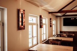 - une salle à manger avec une table, des chaises et des fenêtres dans l'établissement Gasthaus Zum Adler, à Großwallstadt