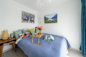 a bedroom with a blue bed and a table with flowers on it at Family Garden House with Free Private Parking & Playground in Riga