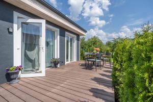 una terraza de madera con mesa y sillas en una casa en Family Garden House with Free Private Parking & Playground, en Riga