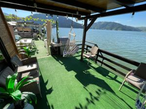 a boat deck with chairs and a hammock on the water at Holiday Bicaz Bungalows On The Lake in Bicaz