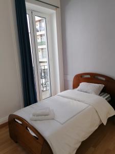 a bedroom with a large bed with a window at Madeirarooms in Funchal