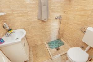 uma casa de banho com um chuveiro, um WC e um lavatório. em Anastasija5 em Herceg-Novi
