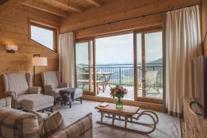 a living room filled with furniture and a large window at Almlodge Westendorf in Westendorf