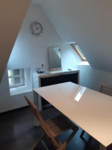 ein Esszimmer mit einem Tisch und einer Uhr an der Wand in der Unterkunft Superbe loft en centre-historique in Quimper
