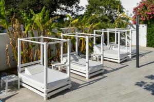 a row of white beds on a patio at Hotel Vibra Marco Polo II - Adults only in San Antonio