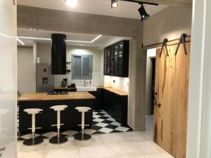 een keuken met zwarte kasten en een zwart-witte geruite vloer bij City Appartment 1 in Athene