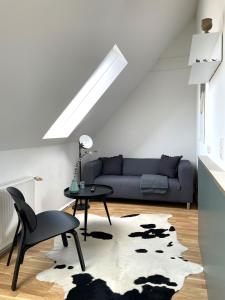a living room with a couch and a table at Bright + Cozy Dachgeschoß Maisonette im Zentrum in Bregenz