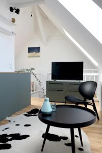 sala de estar con silla y mesa en Bright + Cozy Dachgeschoß Maisonette im Zentrum, en Bregenz