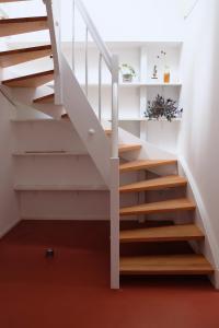 a staircase in a house with white rails and wood steps at Bright + Cozy Dachgeschoß Maisonette im Zentrum in Bregenz