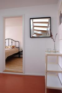 1 dormitorio con espejo y 1 cama en Bright + Cozy Dachgeschoß Maisonette im Zentrum, en Bregenz
